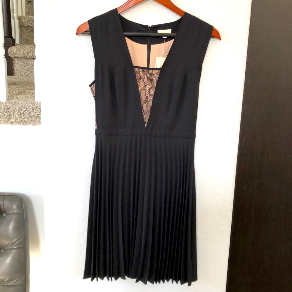 Shoshanna black pleated dress, with beige under lace cutouts.
